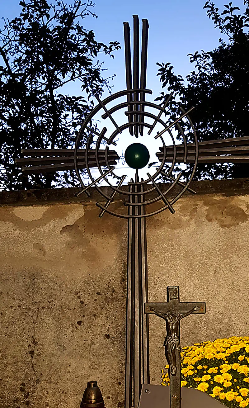 Schmiedeeisernes Grabkreuz mit Strahlenkranz und grünem Glaseinsatz