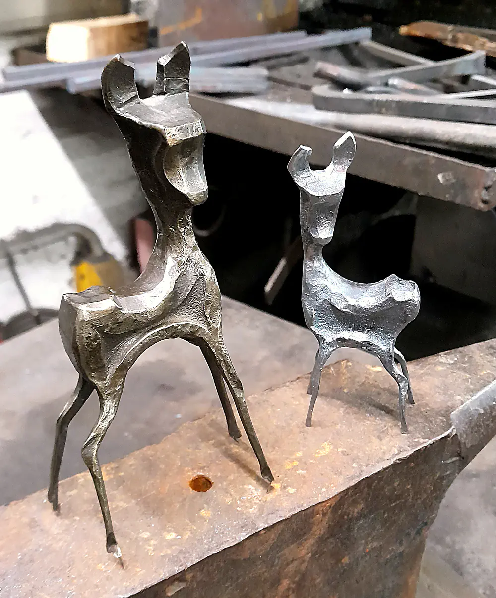 Zwei geschmiedete Rehfiguren auf einem Amboss in der Werkstatt