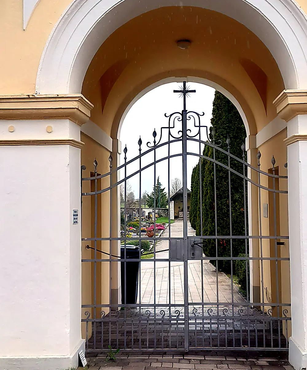 Zweiflügeliges Schmiedeeisentor mit Lanzenspitzen in einem Rundbogen